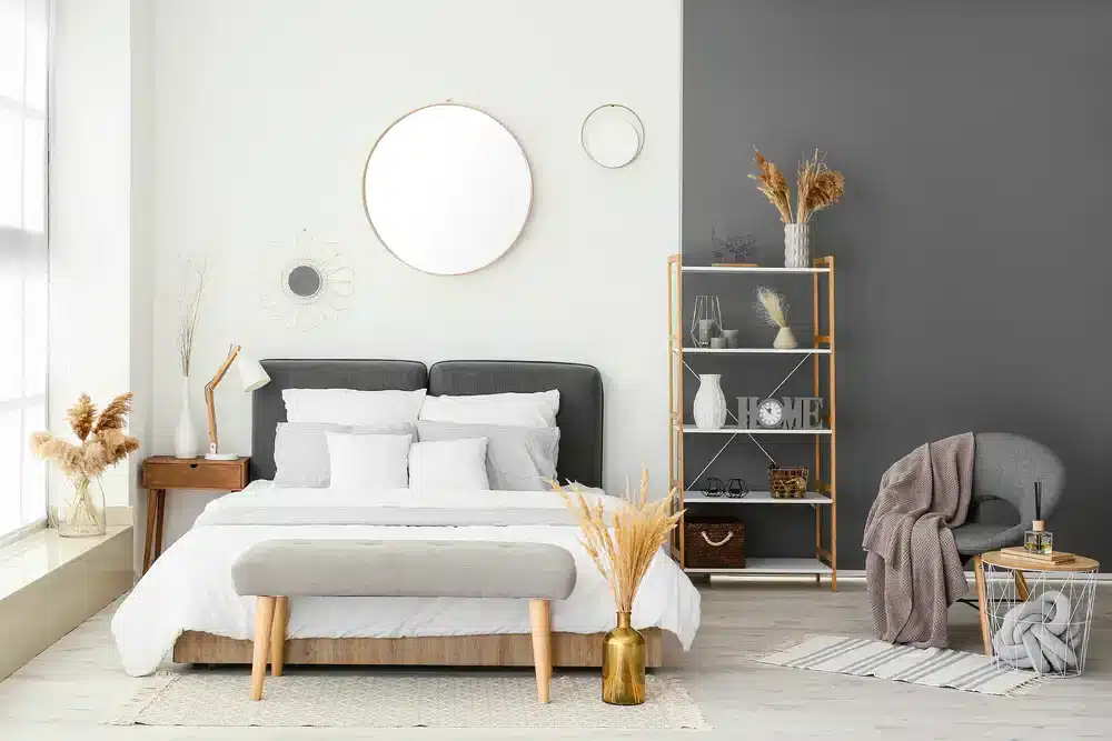 Alternativní návrh ložnice s optimalizací prostoru, kde je jednoduché postelové prádlo doplněno dekorativními prvky a rostlinami pro vytvoření útulné atmosféry.