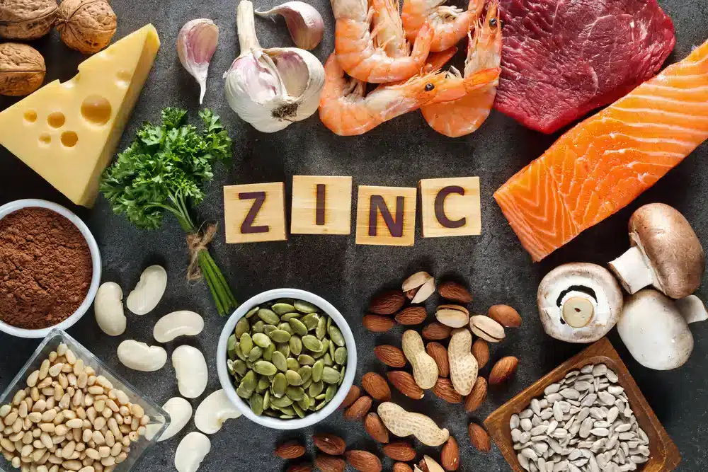 Různé potraviny bohaté na zinek, jako jsou maso, ořechy a luštěniny, které jsou důležité pro zvýšení hladiny testosteronu.