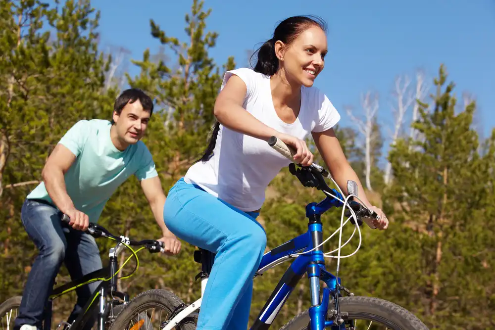 Pár jede na horských kolech, což je další aktivita pro podporu metabolizmu.