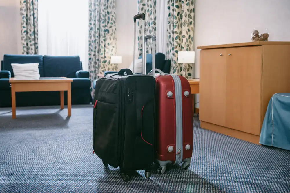 Kufry připravené v hotelovém pokoji – výběr udržitelného ubytování při cestování.